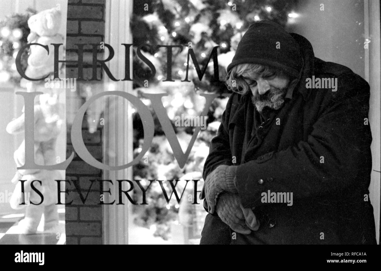 Un senzatetto huddles accanto a un segno negozio durante una frigida notte a Boston ma USA FOTO DI bill belknap 1986 Foto Stock