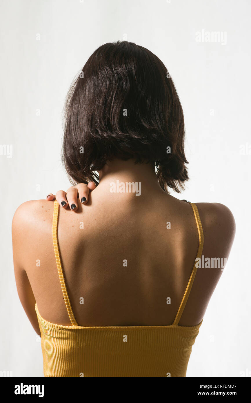 Vista posteriore di una donna mano toccare indietro Foto Stock