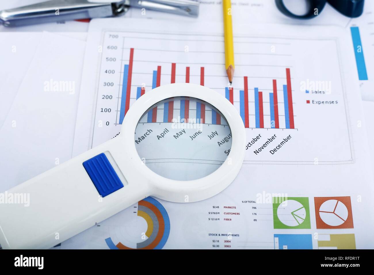 Immagine della carta finanziaria, penna e lente di ingrandimento. Foto Stock