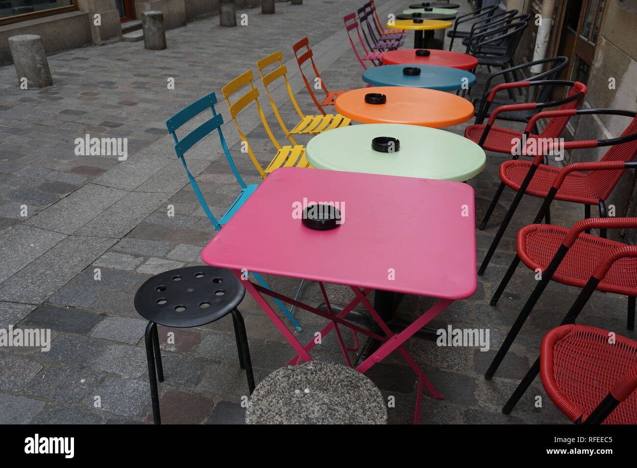 Divertente e colorato i tavoli e le sedie in un cafe' all'aperto in Francia in una strada pedonale Foto Stock