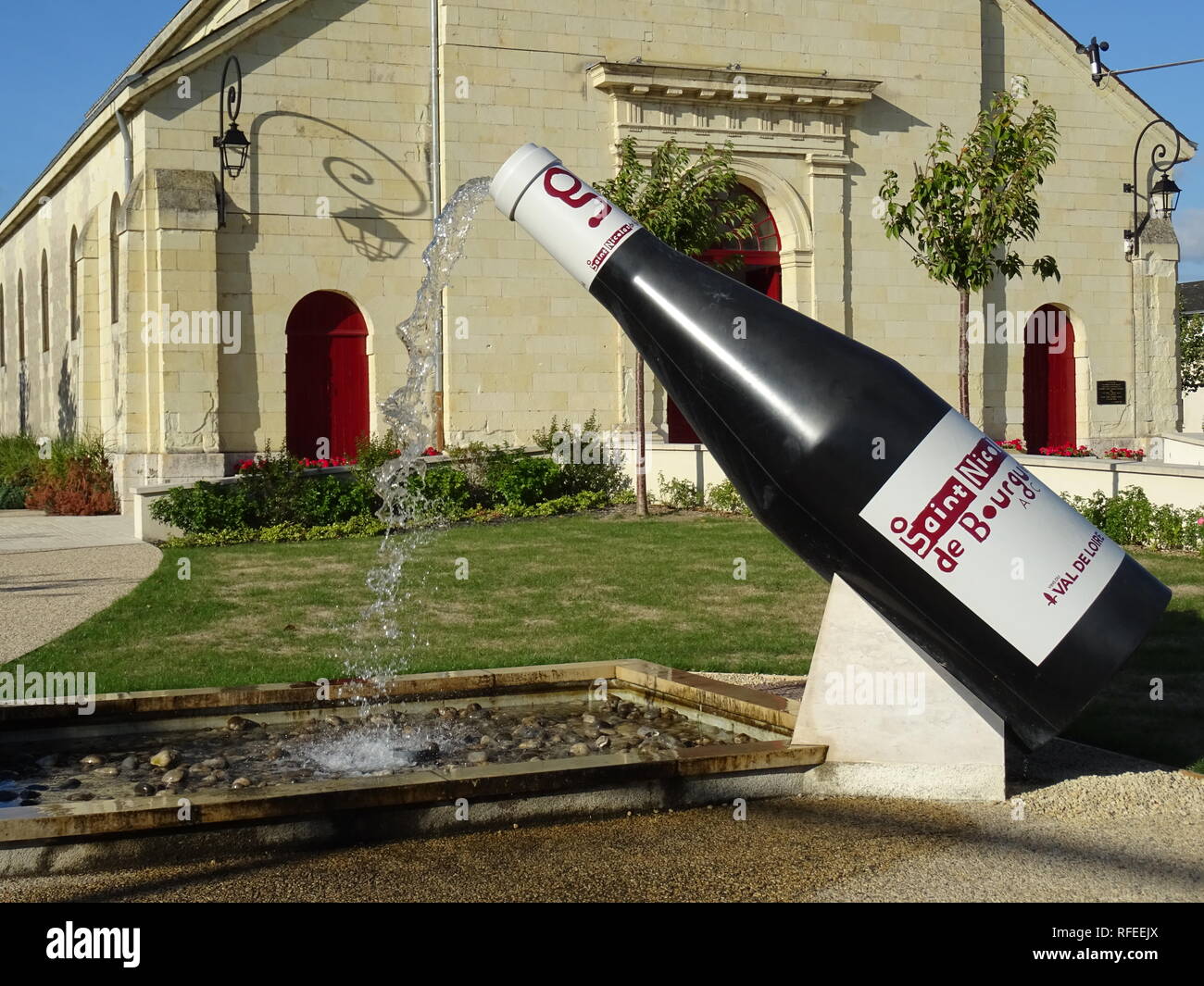 Divertimento bottiglia di vino fontana davanti a una chiesa nel lato del paese in Francia Foto Stock