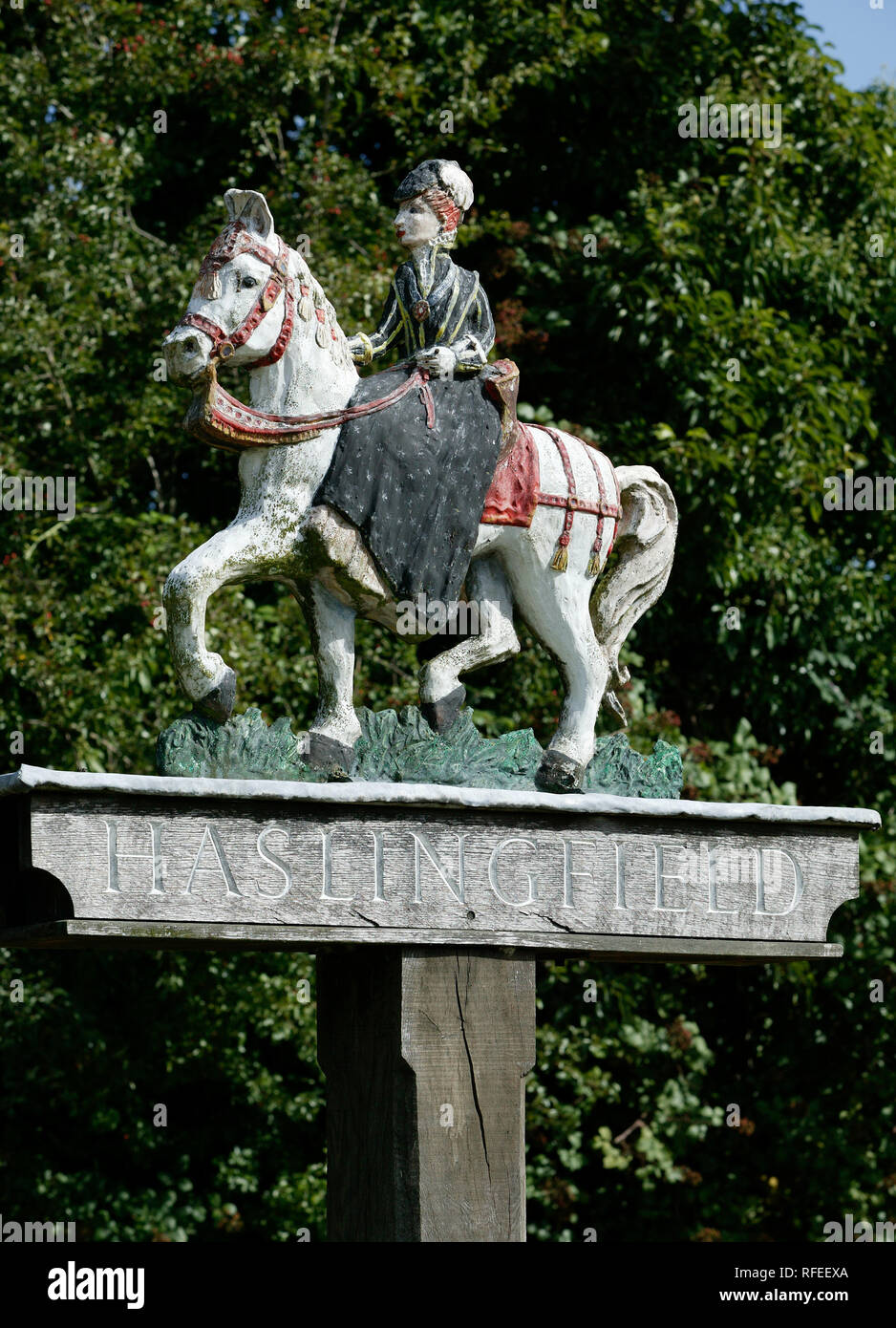Haskingfield Villaggio verniciato firmare con la signora di equitazione sella laterale Foto Stock