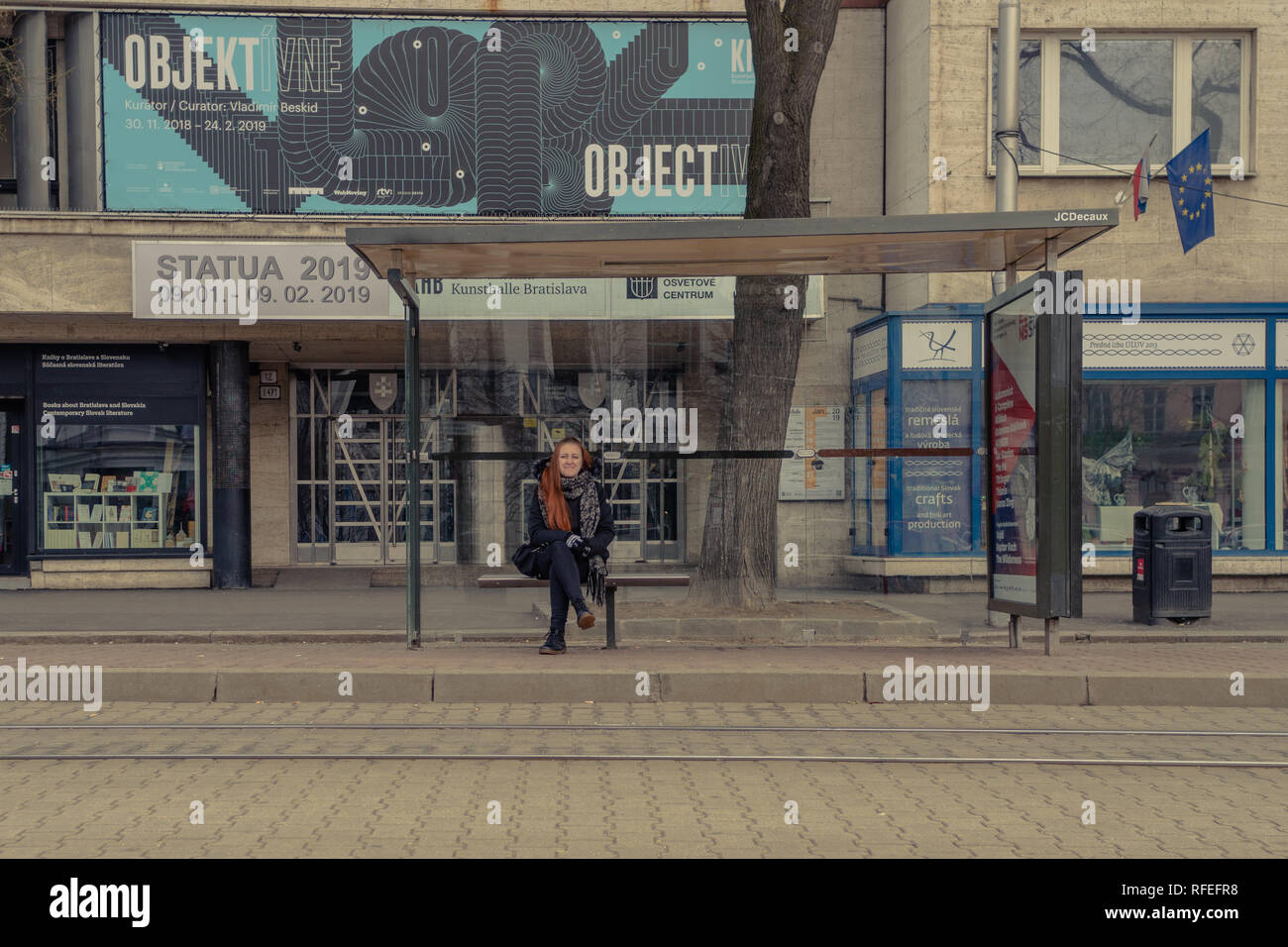 La ragazza è seduta una fermata del tram Foto Stock