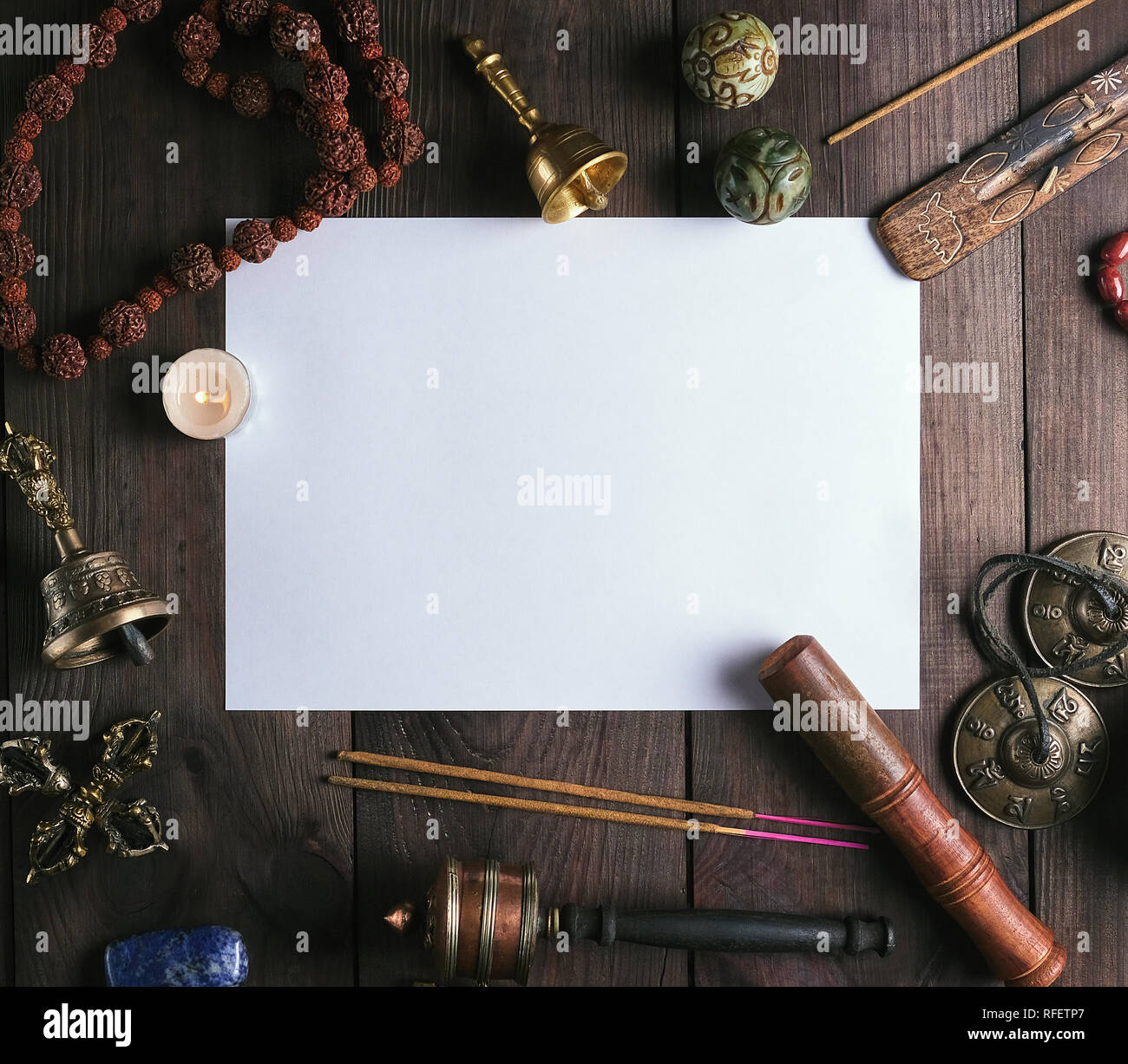 Vuoto foglio bianco nel mezzo di oggetti religiosi per la meditazione, di  rilassamento e massaggio su un marrone di sfondo di legno Foto stock - Alamy