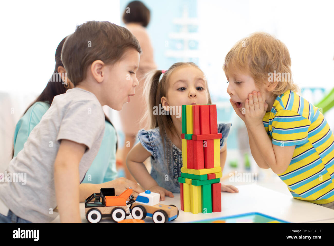 Bambini piccoli costruire giocattoli di legno a casa o asilo nido. Emozionante giocare i ragazzi con i blocchi di colore. Giocattoli educativi per la scuola materna e asilo nido i bambini. Foto Stock