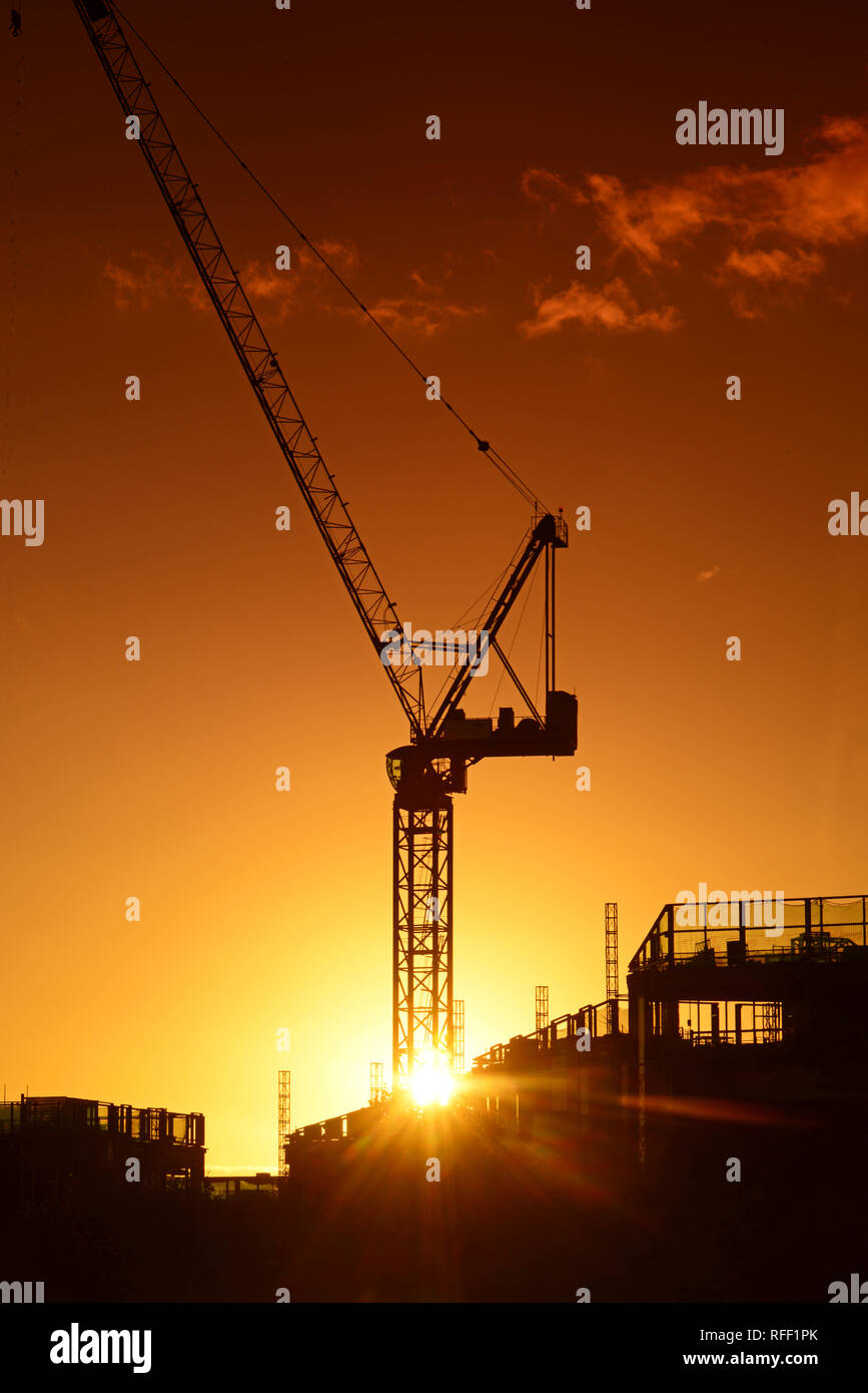 Gru sul sito di costruzione al tramonto su Leeds City skyline Yorkshire Regno Unito Foto Stock