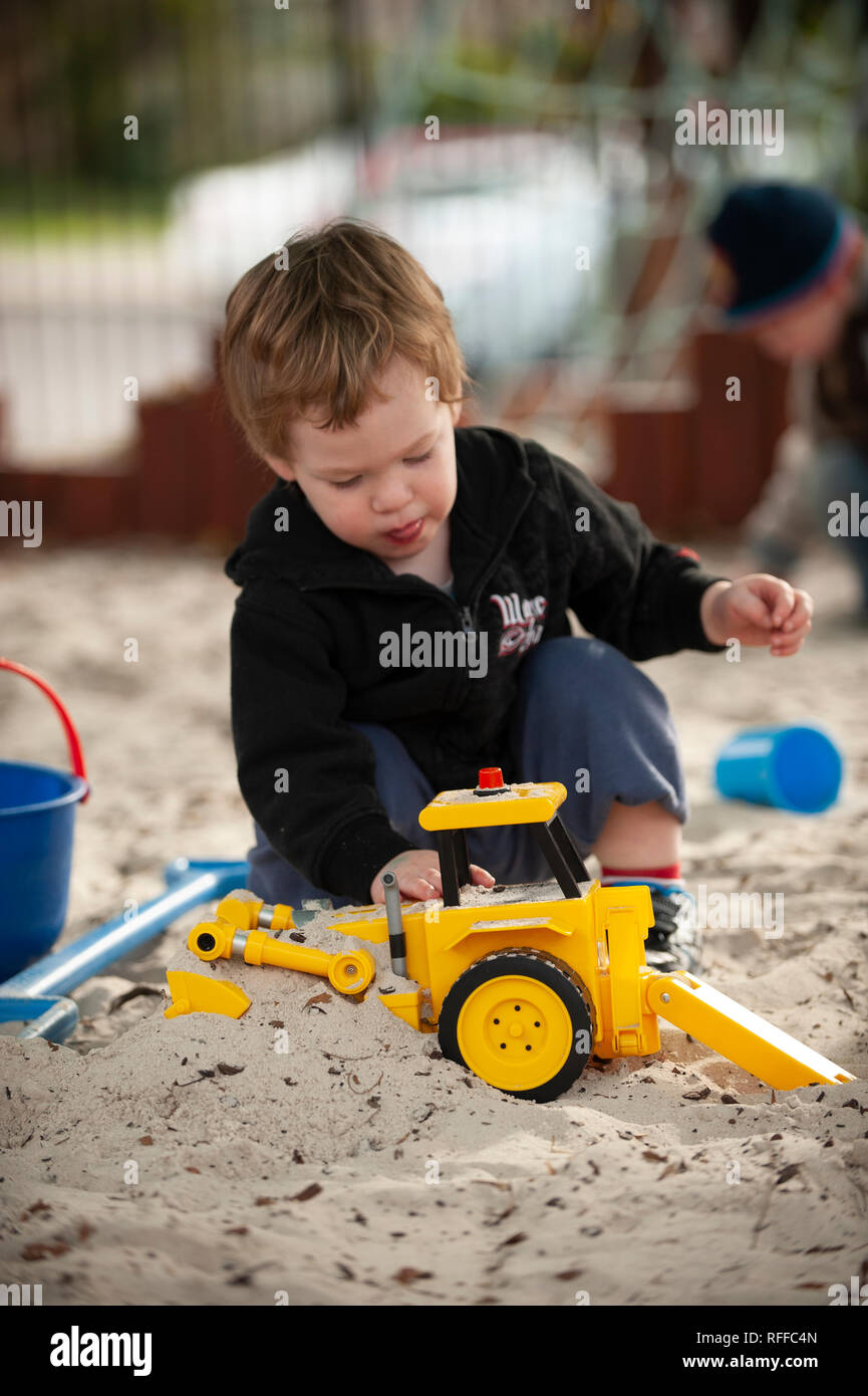 Il Toddler giocando in una buca di sabbia Foto Stock