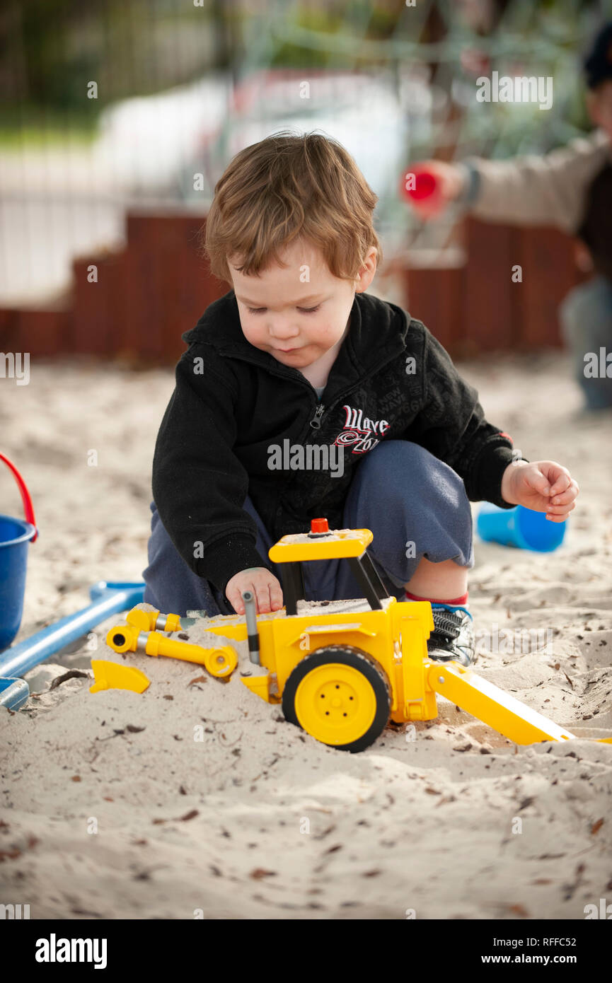 Il Toddler giocando in una buca di sabbia Foto Stock