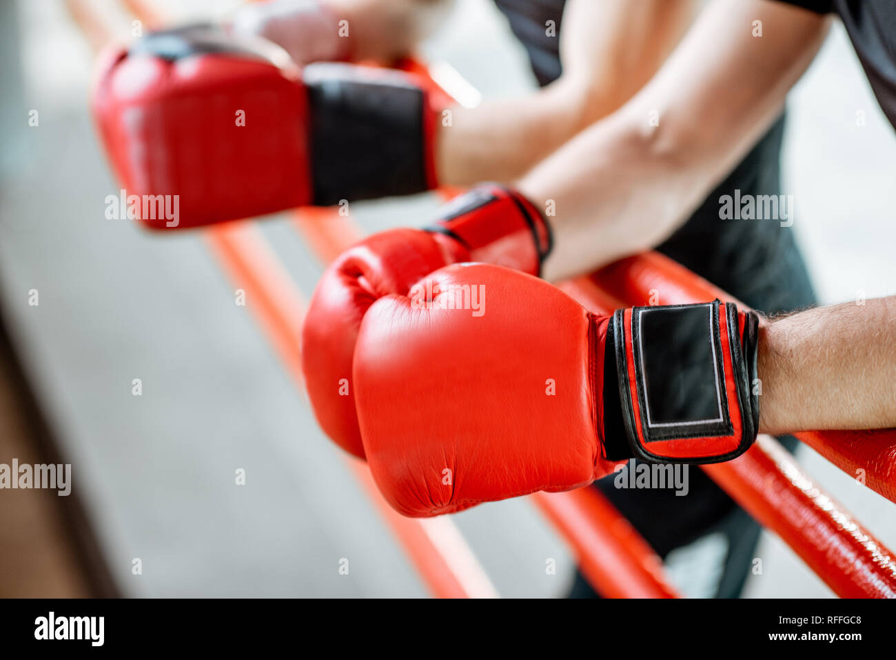 Boxer in appoggio sul pugilato ring, vista ravvicinata sul guantoni da pugilato sulle funi Foto Stock