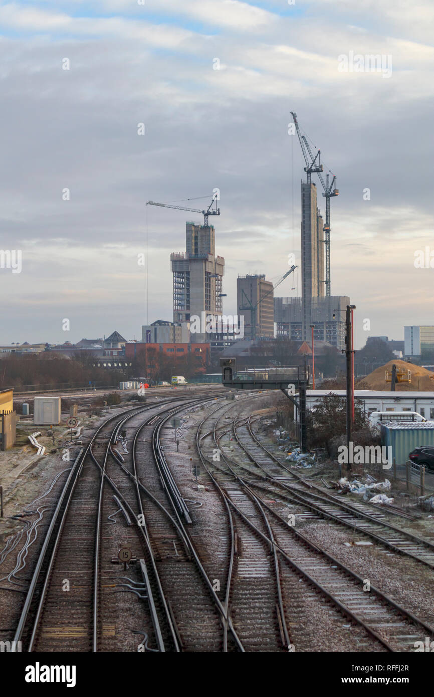 La modifica sullo skyline di Woking, Surrey: tracce ferroviarie il piombo in gru a torre e nuovo alto luogo Victoria Square sviluppo della vendita al dettaglio nel centro della città Foto Stock