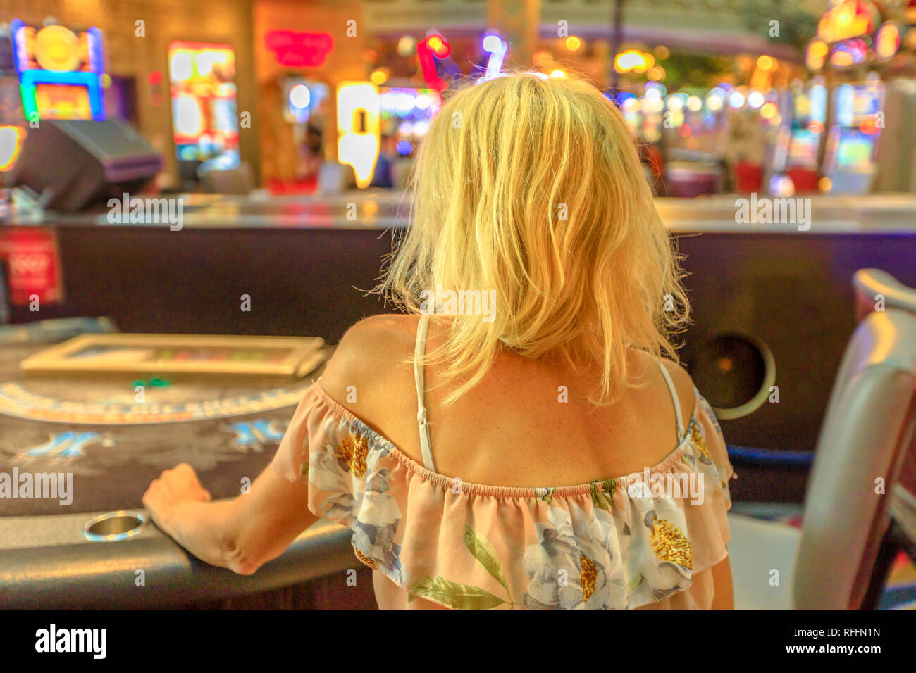 Caucasian donna bionda il gioco d'azzardo nel casino seduti al tavolo del blackjack. Gambler addict concetto. Lifestyle ragazza giocare nei casinò di Las Vegas, Nevada Foto Stock