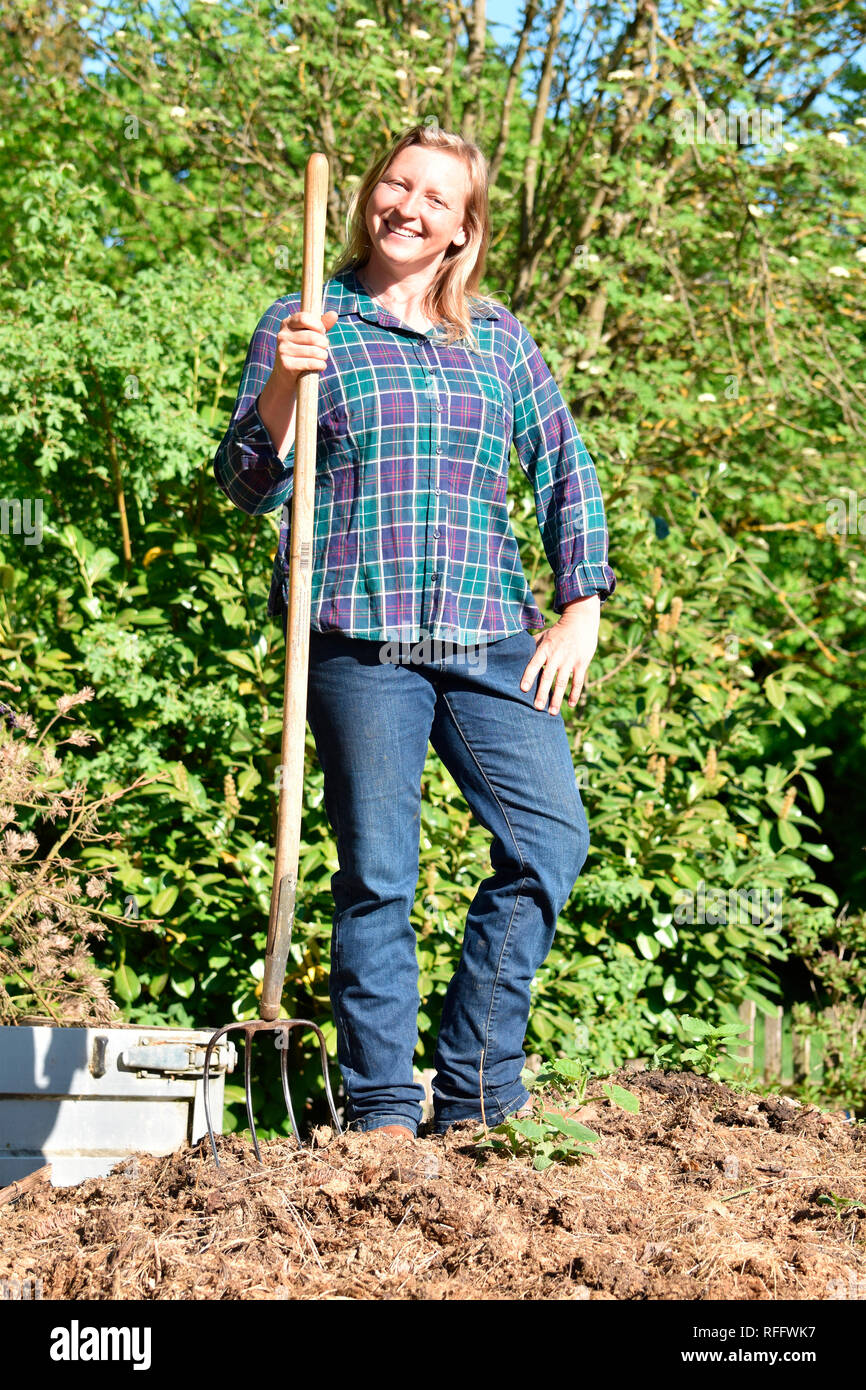 Donna mucking, letame equino, muck-rastrello, forca letame, muck-heap Foto Stock