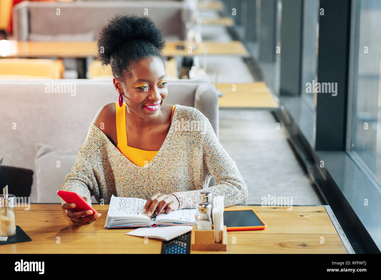 Curly sentimento donna gioiosa mentre studiano lingua straniera Foto Stock Curly sentimento donna gioiosa mentre studiano lingua straniera Foto Stock