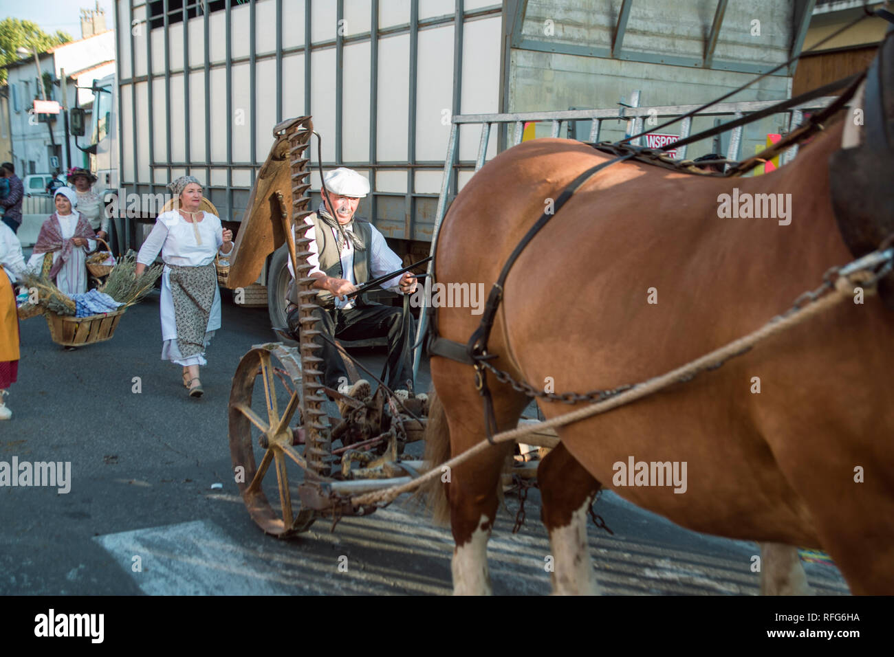 Antique cavallo e falciatrice nella vecchia scuola sfilata dei mestieri tradizionali alla sagra annuale, Saint Gilles, Gard, Francia Foto Stock