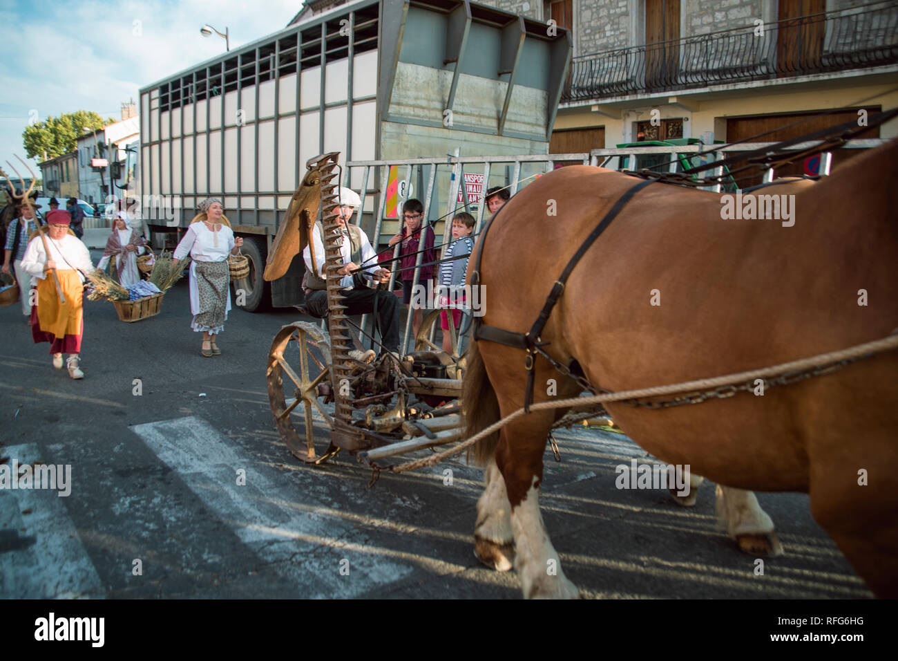 Antique cavallo e falciatrice nella vecchia scuola sfilata dei mestieri tradizionali alla sagra annuale, Saint Gilles, Gard, Francia Foto Stock