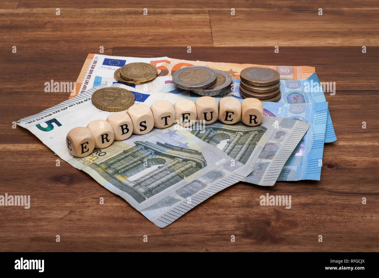 Die Euro Geldscheine und Münzen liegen auf dem Tisch mit dem Wort Erbsteuer Foto Stock