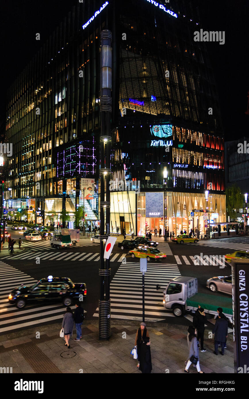La Ginza Tokyo di notte, le vetture a guidare oltre il zabra scramble crossing presso l'angolo dell'illuminato Tokyu Plaza edificio con il Bally stor Foto Stock