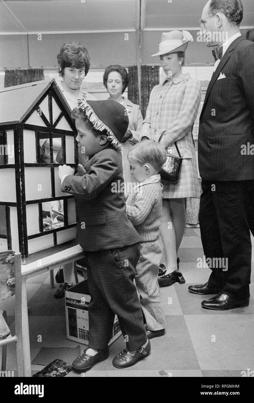 Princess Anne guardato un ragazzo giovane indagare una casa delle bambole al D'Arcy Street il centro del gioco in Moss Side, dove la principessa Royal fermato da durante la sua visita a Manchester. Foto Stock