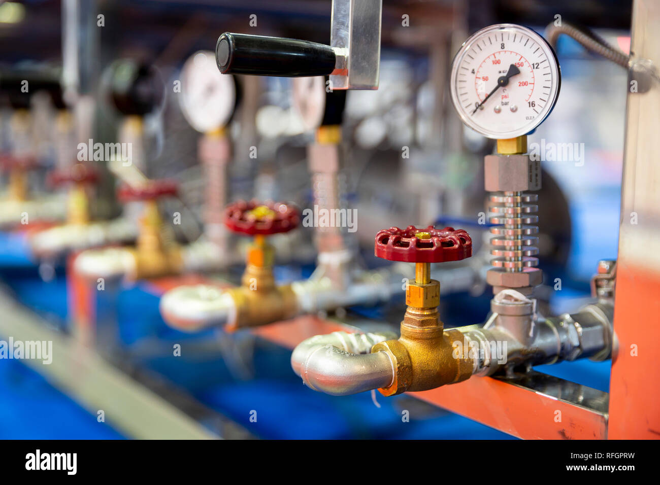 Pressione di strumento di misura - bar, psi. Red valvole metalliche sulle tubazioni. Un dispositivo di pressione per il sistema dell'industria. Foto Stock
