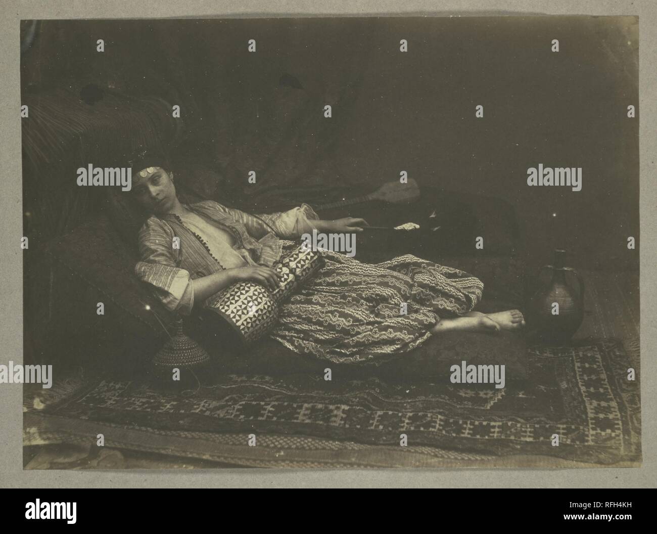 [Reclino' Odalisca]. Artista: Roger Fenton (British, 1819-1869). Dimensioni: 28,5 x 39 cm (11 1/4 x 15 3/8 in.). Data: 1858. Fenton ha realizzato una serie di fotografie ispirate al Victorian vogue per le esotiche bardature di impero, modellato sull'harem scene e odalisques di Eugène Delacroix e Jean-Auguste-Dominique Ingres che aveva visto a Parigi, e motivata dal desiderio di elevare lo status della fotografia di affrontare i temi più frequentemente trattati in pittura. <p> 'Reclino' Odalisca" è tra i più silenziosi di foto nella sua serie. Non ci sono accovacciata schiavi o leering sultani, n Foto Stock