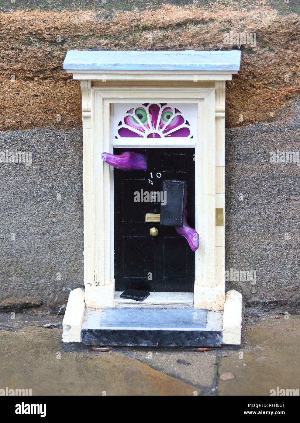 Cambridge, Regno Unito. 25 gennaio, 2019. Una piccola copia del famoso porta anteriore per il primo ministro britannico ha la residenza, n. 10 di Downing Street, Londra visto a Downing Street, Cambridge. Mistero gli artisti di strada che con lo pseudonimo di "inky porte' sono responsabili per l'installazione, che è la più recente di un progetto in corso. Ad oggi non vi sono 'dinky porte' alla realtà pedina su Parker's pezzo e il Teleport-O-Matic macchina tra telefono rosso scatole da la grande chiesa di Santa Maria in città. Credito: SOPA Immagini limitata/Alamy Live News Foto Stock