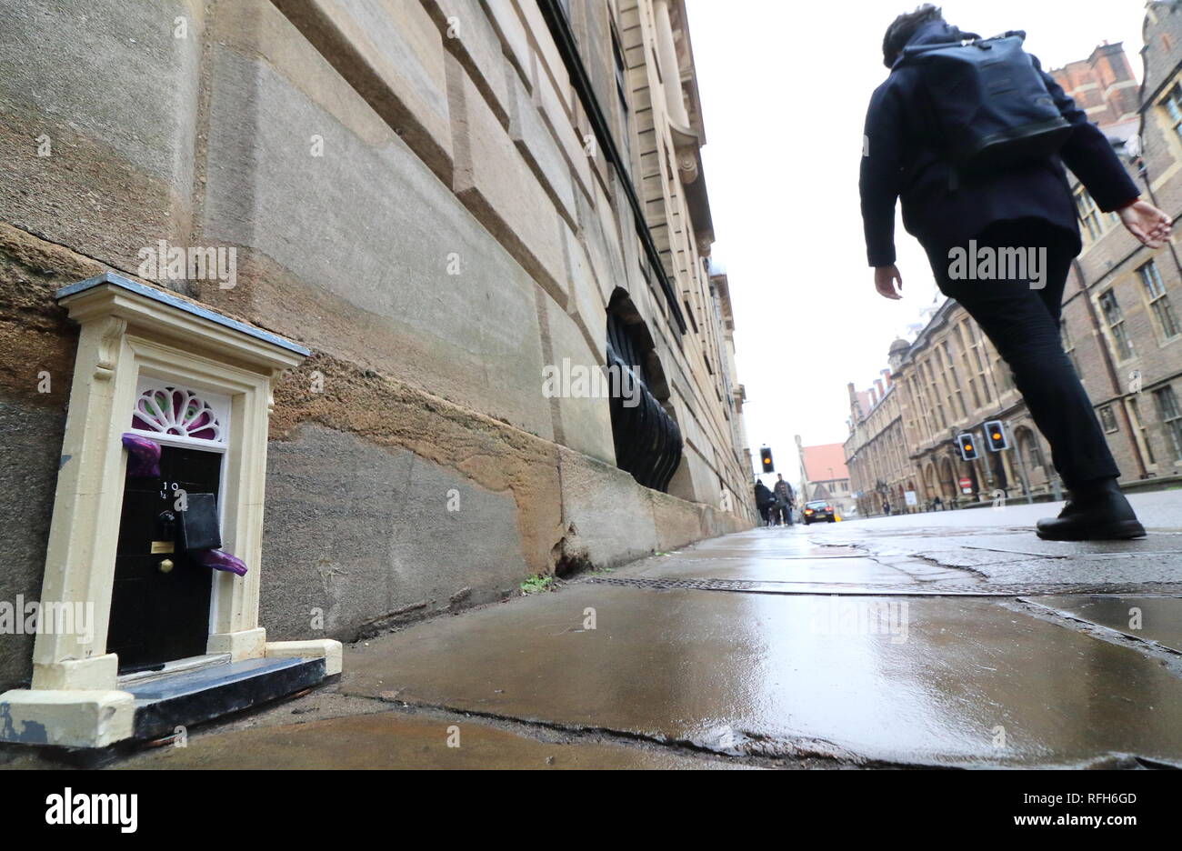Cambridge, Regno Unito. 25 gennaio, 2019. Una piccola copia del famoso porta anteriore per il primo ministro britannico ha la residenza, n. 10 di Downing Street, Londra visto a Downing Street, Cambridge. Mistero gli artisti di strada che con lo pseudonimo di "inky porte' sono responsabili per l'installazione, che è la più recente di un progetto in corso. Ad oggi non vi sono 'dinky porte' alla realtà pedina su Parker's pezzo e il Teleport-O-Matic macchina tra telefono rosso scatole da la grande chiesa di Santa Maria in città. Credito: SOPA Immagini limitata/Alamy Live News Foto Stock