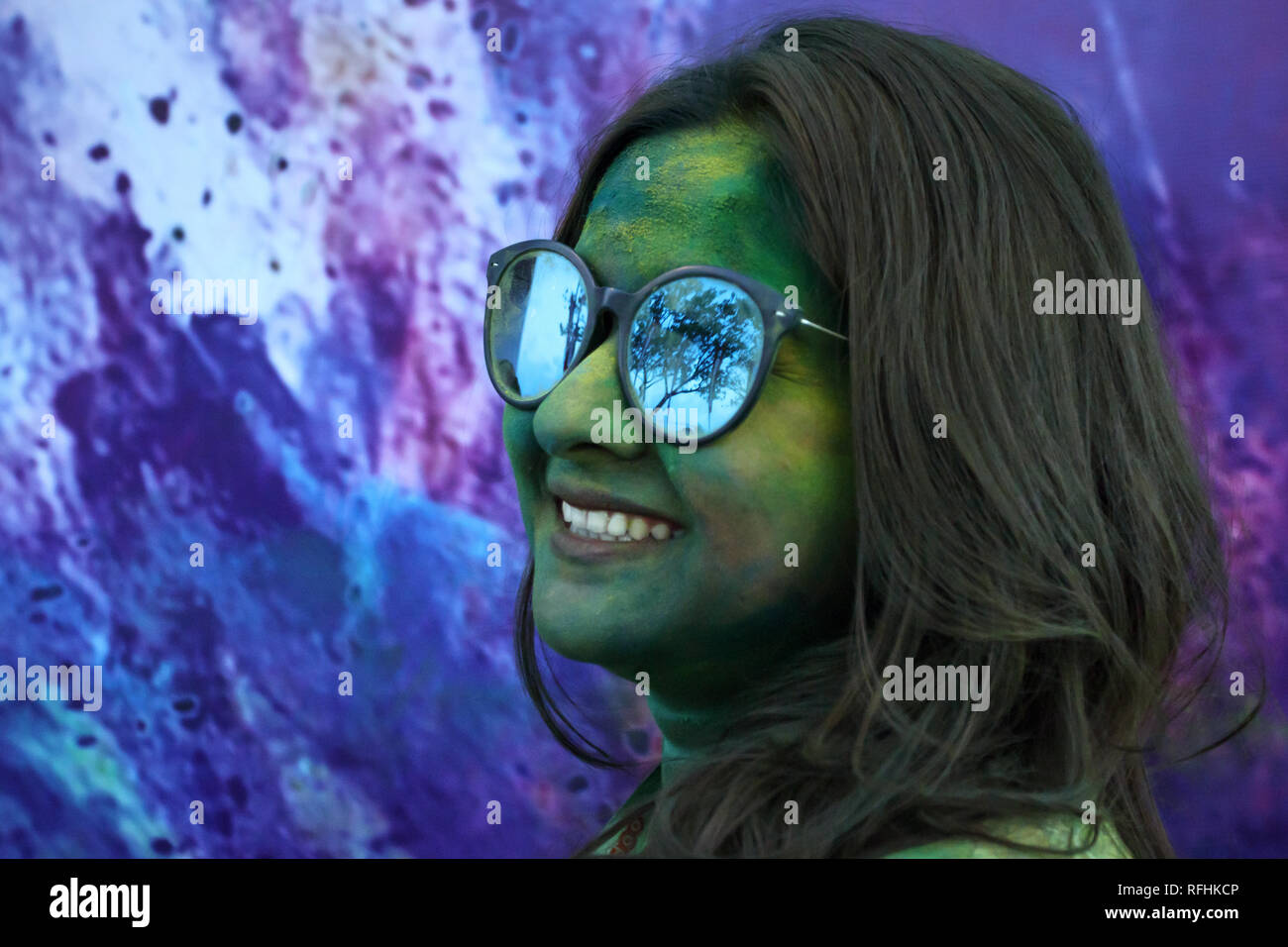 Ritratto di donna in occhiali da sole con colori dipinto sul suo viso durante il colore eseguire celebrazione in Hulhumale, Maldive Foto Stock