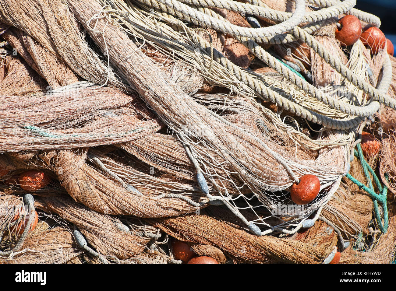 Close up sullo sfondo di un mucchio di bobine di pesca in mare net con colorate galleggianti vivaci e corde di cavo a porto Foto Stock