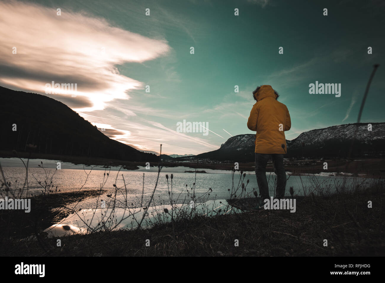Giovane donna in piedi da sola corsa Outdoor Lifestyle e malinconia emozioni concetto nebbiose invernali natura sullo sfondo a un lago Foto Stock