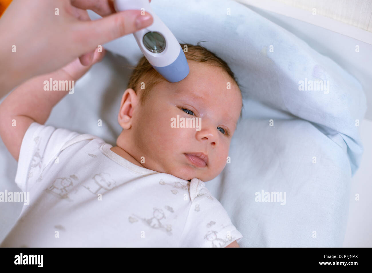 Misurazione di temperatura del bambino con termometro senza contatto. La  mamma misura la temperatura corporea del bambino con un termometro Foto  stock - Alamy