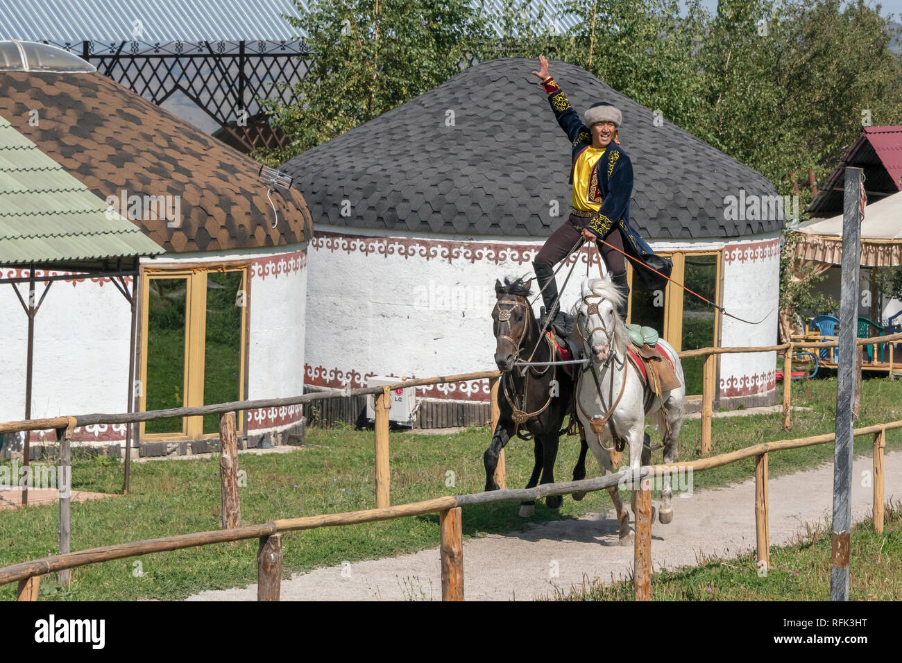 Il kazako trick rider su due cavalli, equitazione da yurta, Alamty, Kazakistan Foto Stock