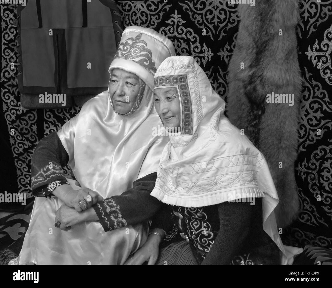 Due nonne guardare i loro nipoti all'interno di una yurt, Almaty, Kazakhstan Foto Stock