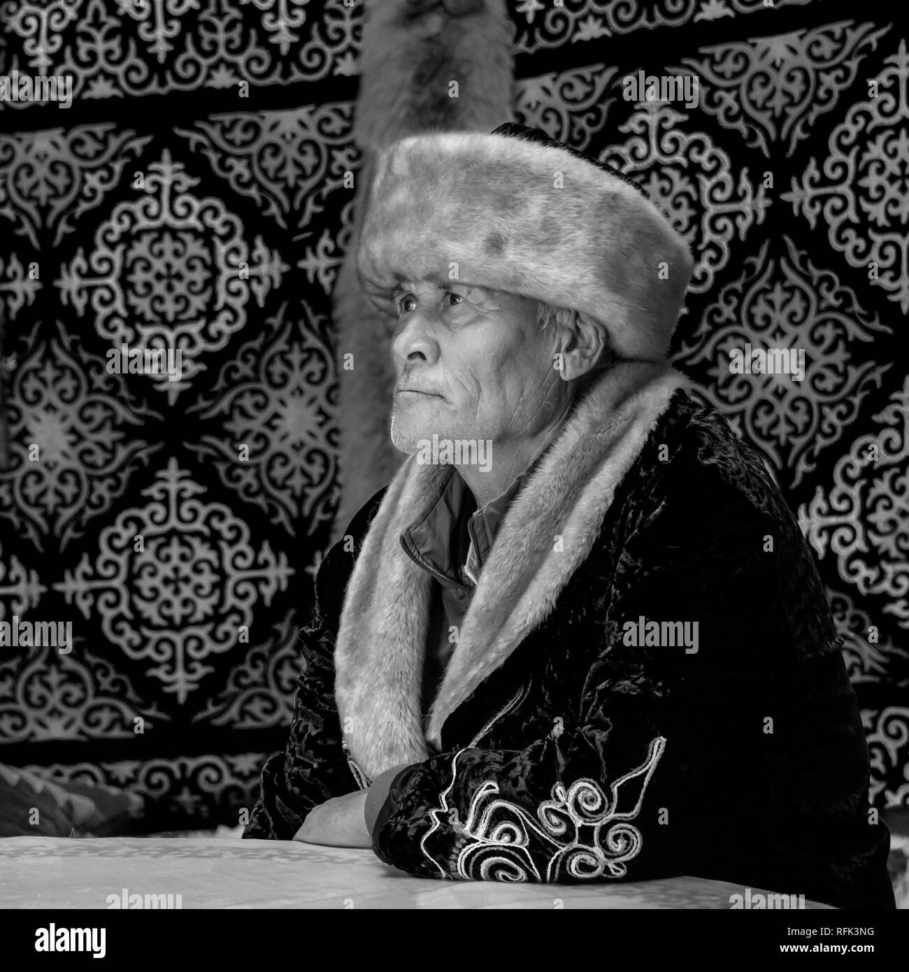 Ritratto di un uomo kazako in abito tradizionale, con fox pelle sulla parete del yurt BW, Almaty, Kazakhstan Foto Stock