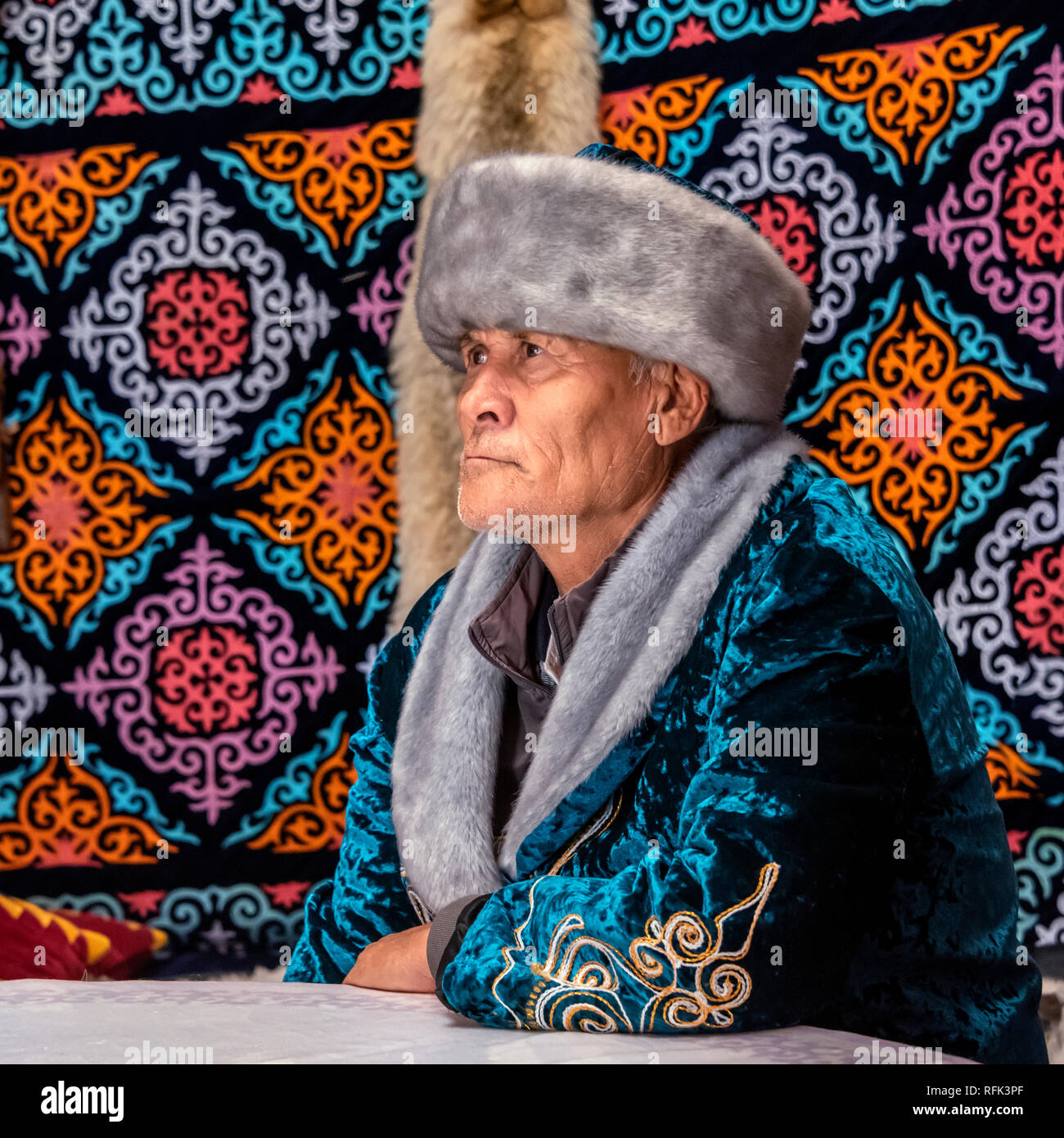 Ritratto di un uomo kazako in abito tradizionale, con fox pelle sulla parete del yurt, Almaty, Kazakhstan Foto Stock