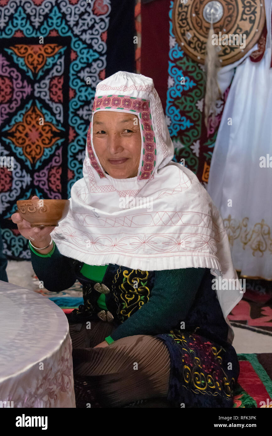 Il kazako donna in abito tradizionale bere il tè in una yurt, Almaty, Kazazhstan Foto Stock