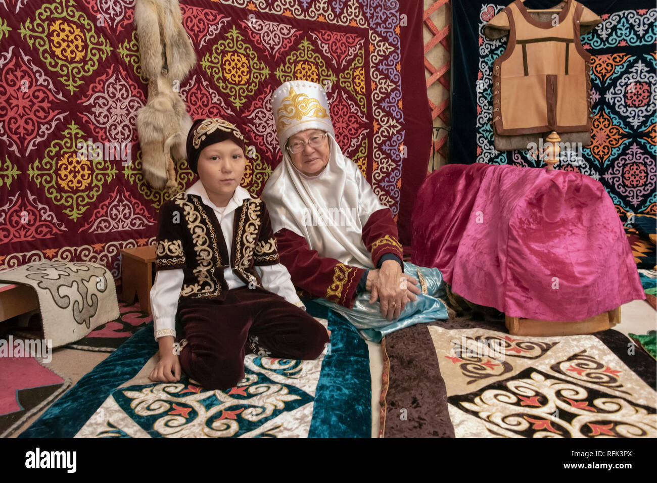 Nonna e nipote in costumi tradizionali all'interno di una yurt, Almaty, Kazakhstan Foto Stock