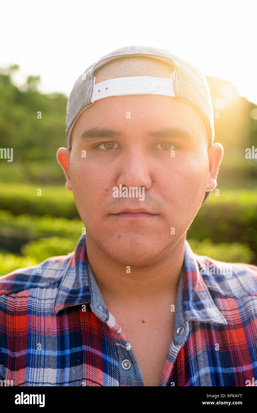 Giovane uomo asiatico che indossa il tappo durante i momenti di relax presso il parco in Bangko Foto Stock