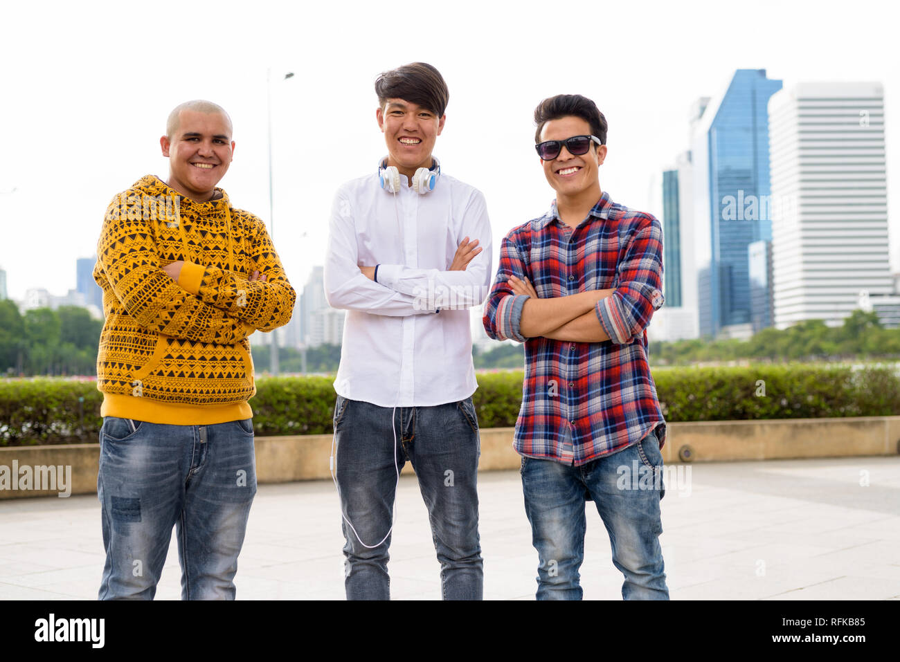 Tre giovani uomini asiatici di relax presso il parco insieme Foto Stock