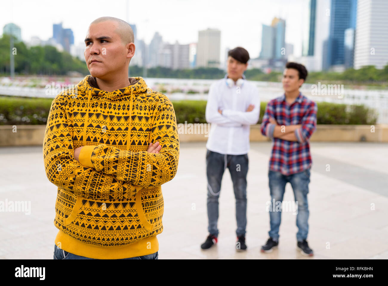 Tre giovani uomini asiatici di relax presso il parco insieme Foto Stock