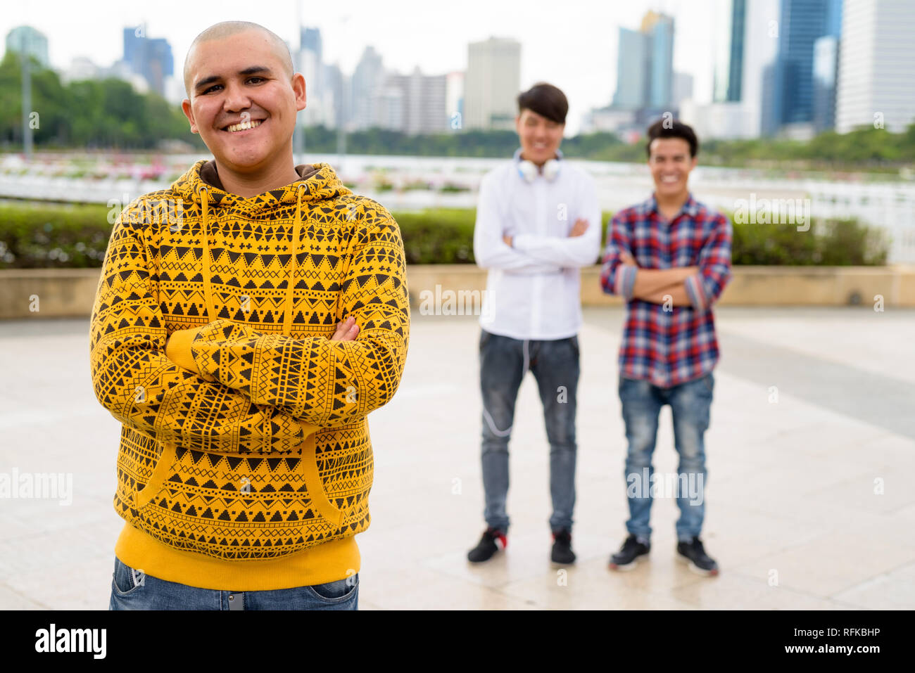 Tre giovani uomini asiatici di relax presso il parco insieme Foto Stock