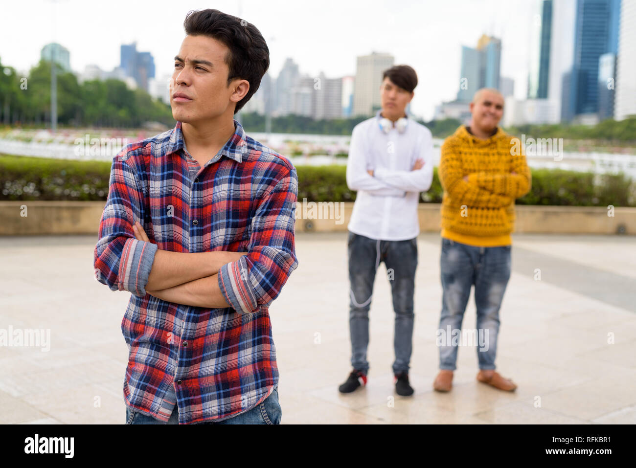 Tre giovani uomini asiatici di relax presso il parco insieme Foto Stock