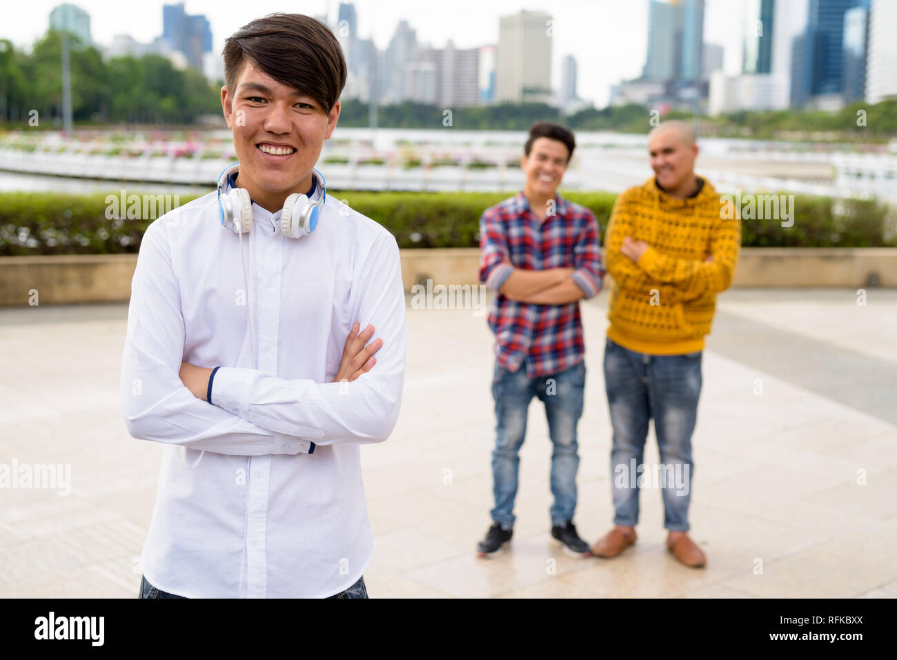 Tre giovani uomini asiatici di relax presso il parco insieme Foto Stock