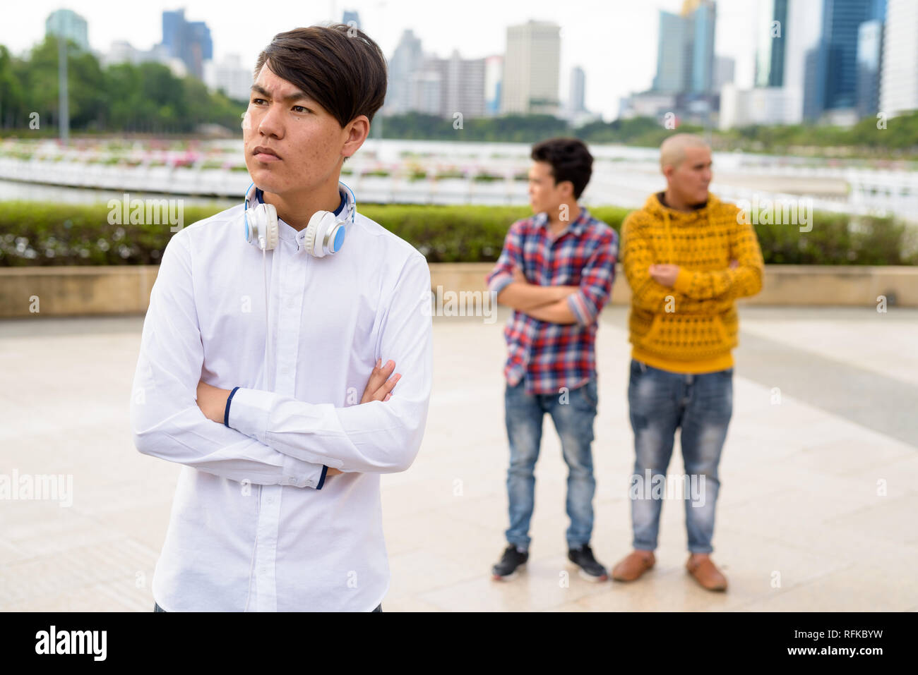 Tre giovani uomini asiatici di relax presso il parco insieme Foto Stock