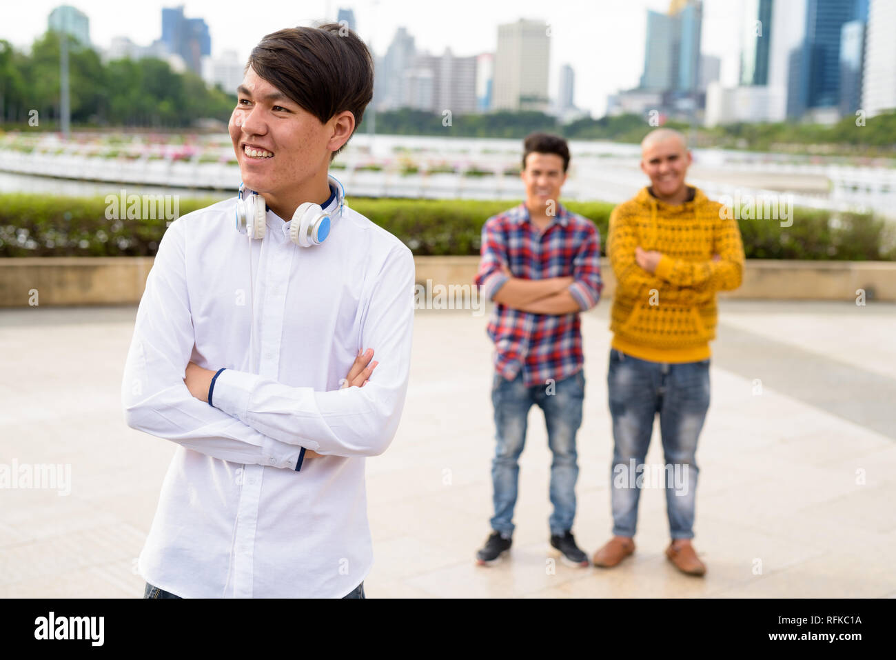 Tre giovani uomini asiatici di relax presso il parco insieme Foto Stock
