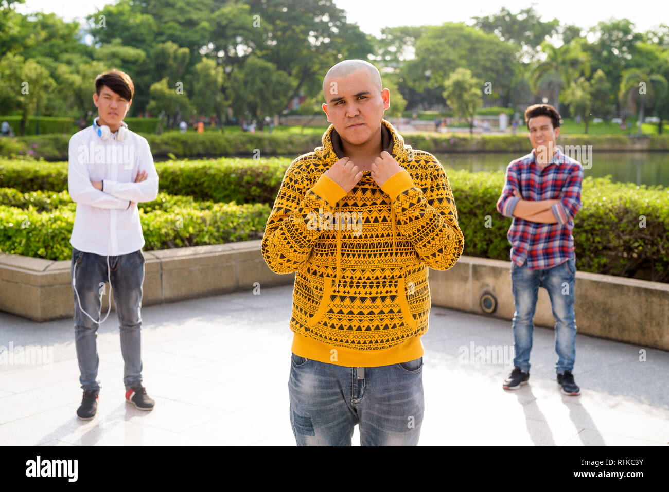 Tre giovani uomini asiatici di relax presso il parco insieme Foto Stock