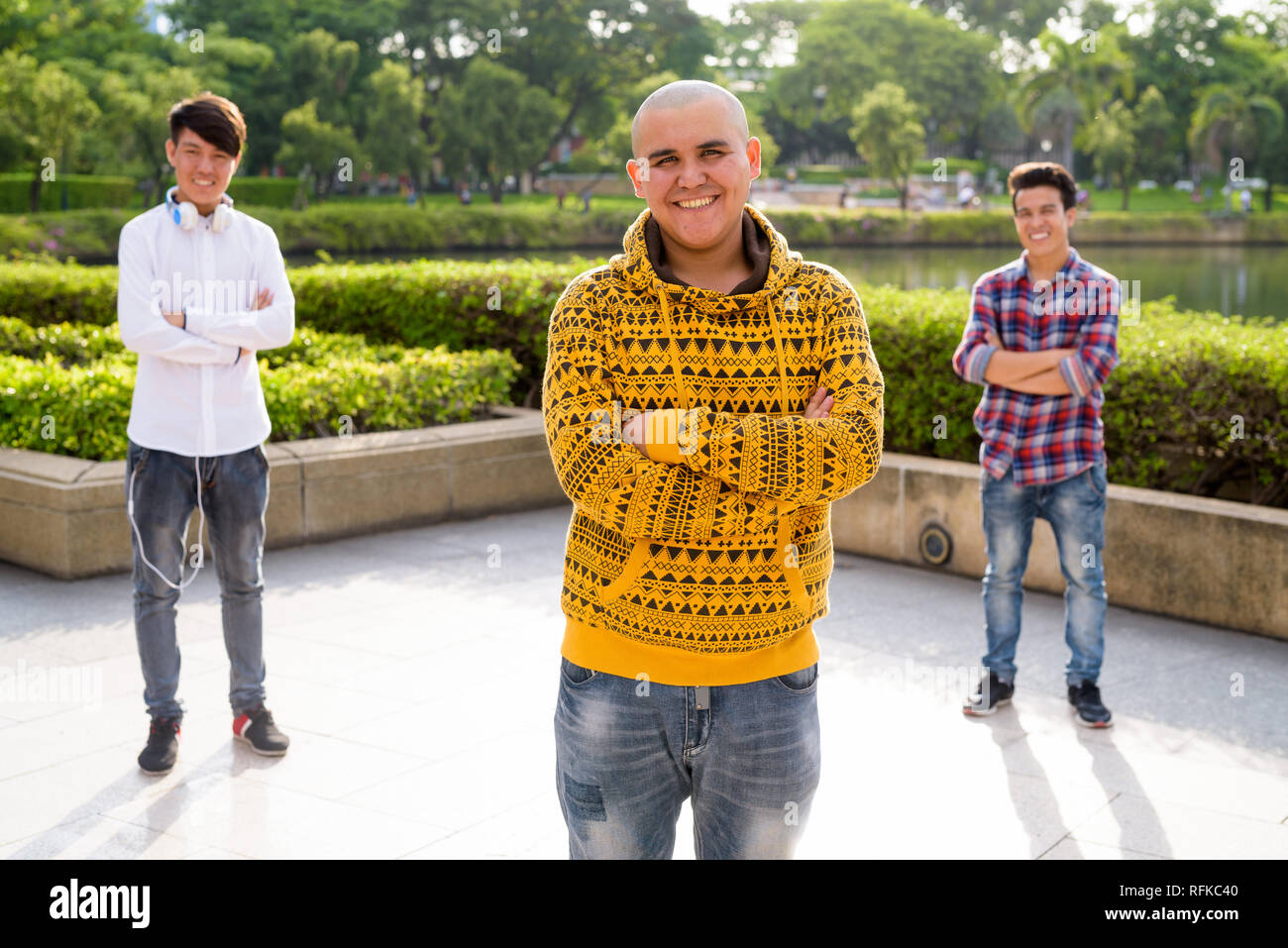 Tre giovani uomini asiatici di relax presso il parco insieme Foto Stock