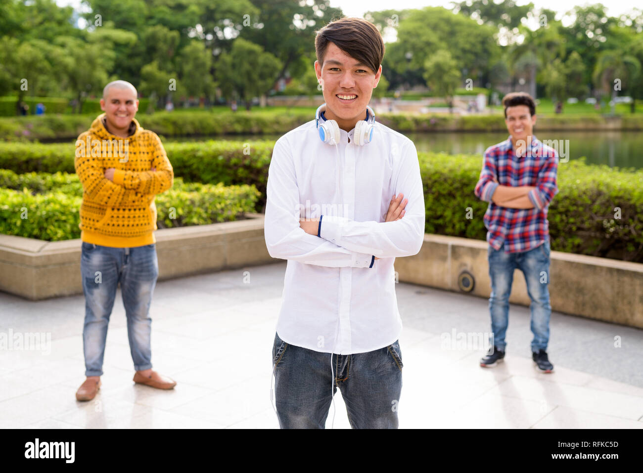 Tre giovani uomini asiatici di relax presso il parco insieme Foto Stock