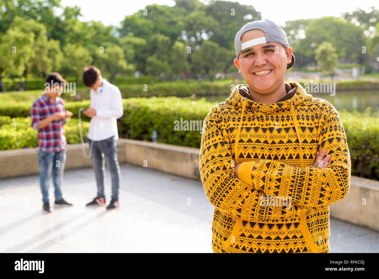 Tre giovani uomini asiatici di relax presso il parco insieme Foto Stock