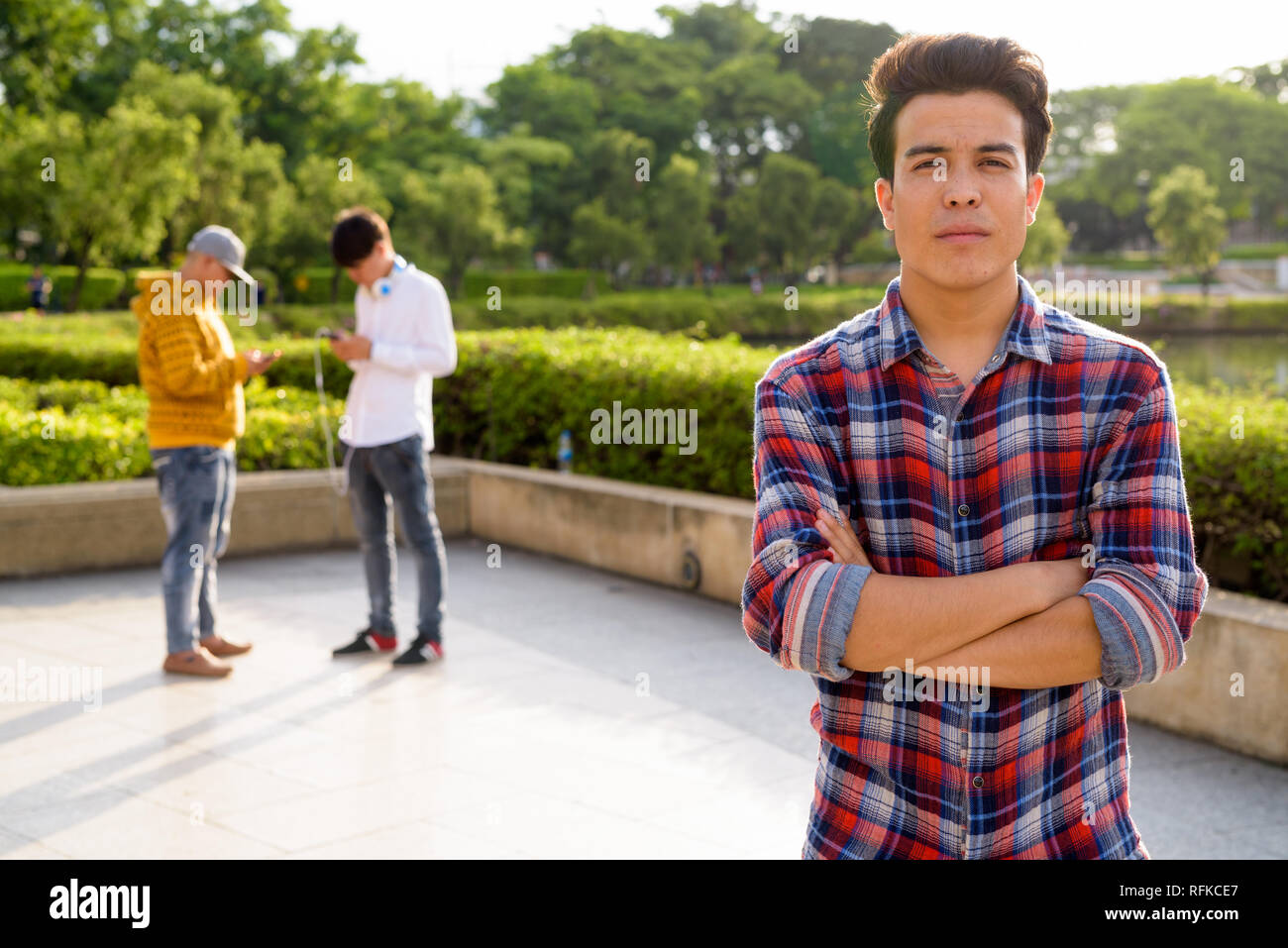 Tre giovani uomini asiatici di relax presso il parco insieme Foto Stock