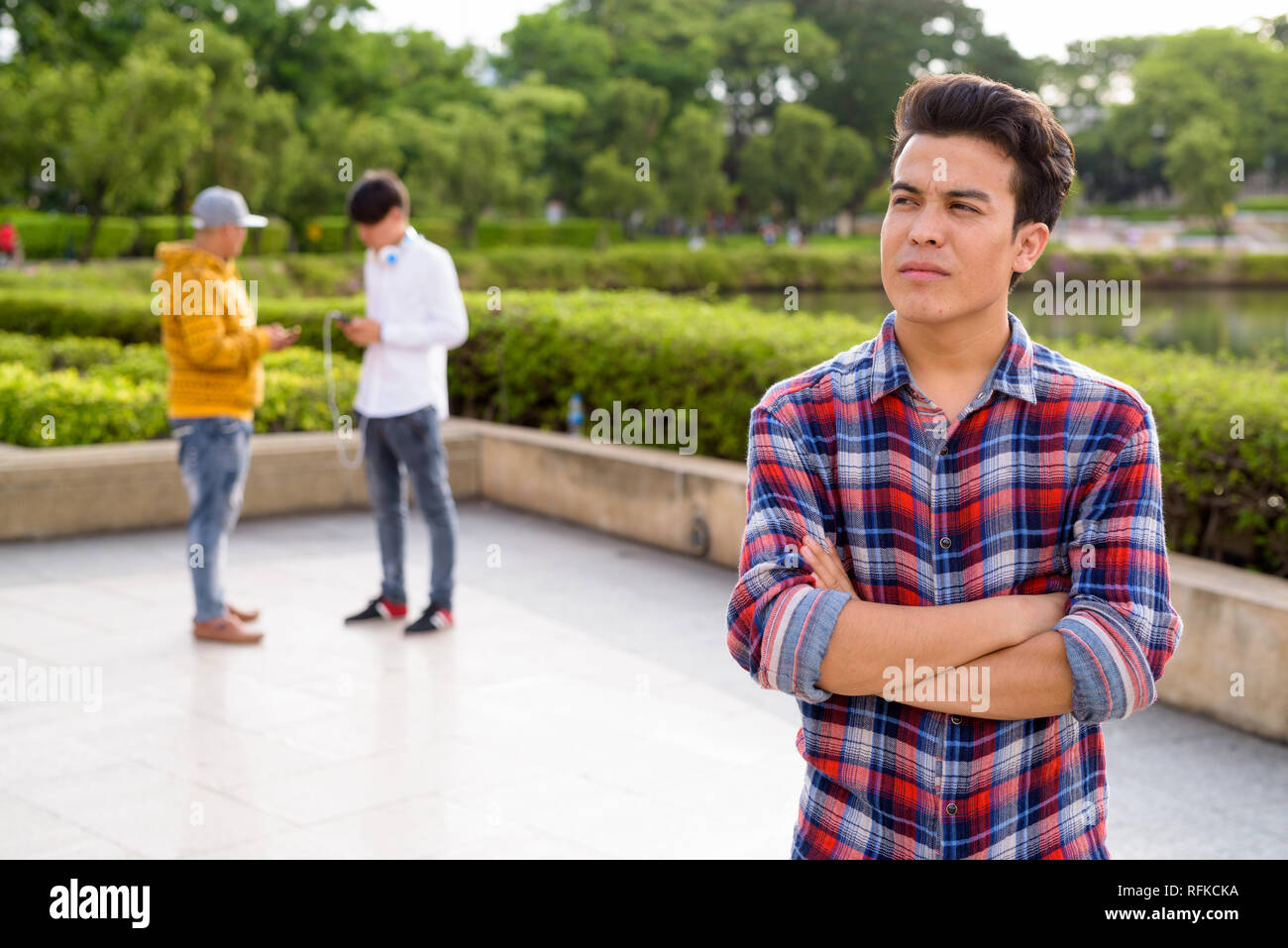 Tre giovani uomini asiatici di relax presso il parco insieme Foto Stock